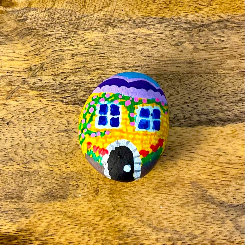 Detailed colorful house, hand painted on a stone